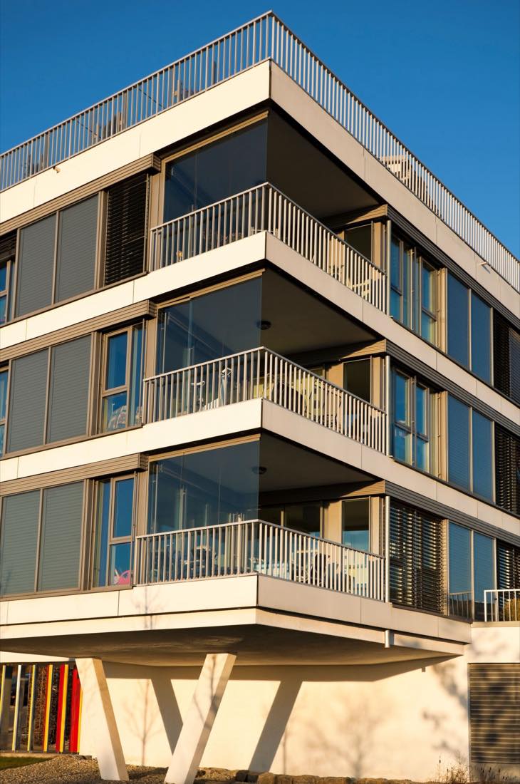 Modernes Mehrfamilienhaus mit Balkonen im Abendlicht