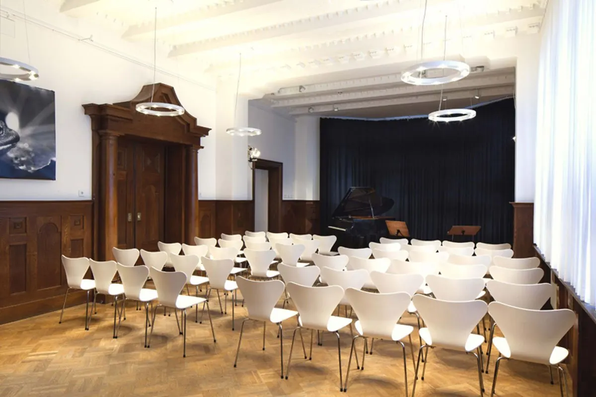 Zenzl-Mühsam-Saal in der Seidlvilla mit Holzvertäfelung und Stuhlreihen