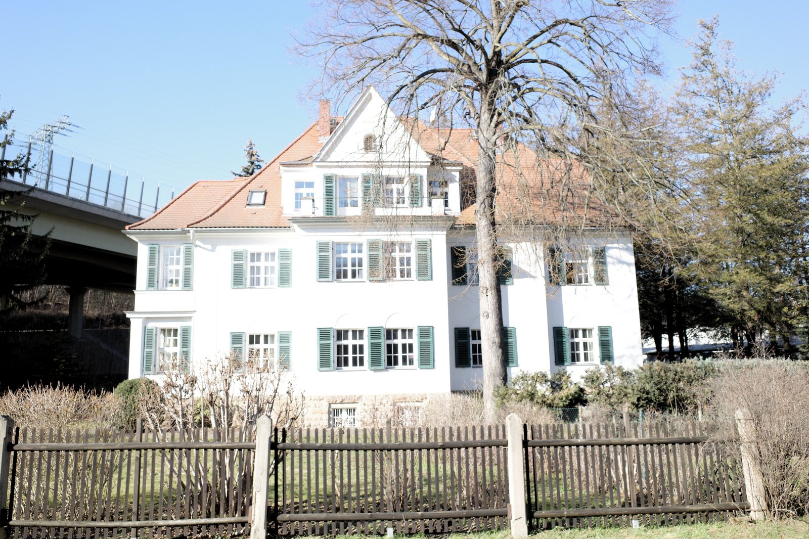 Mehrfamilienhaus mit Garten, Baum und Holzzaun