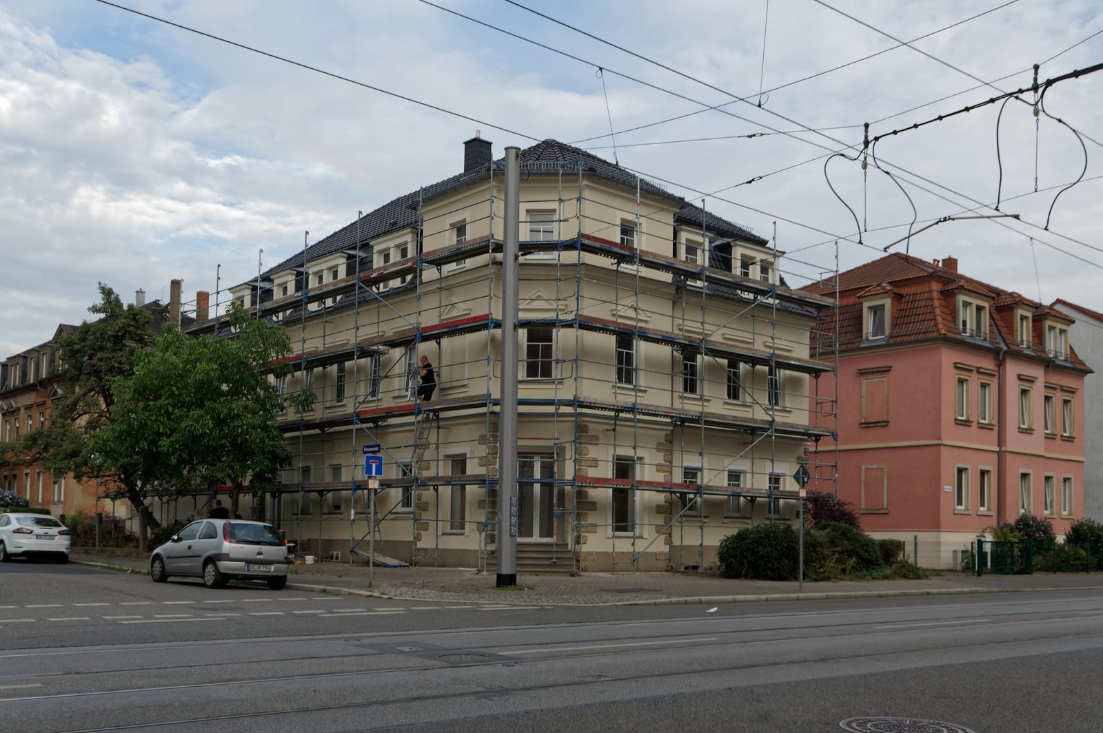 Mehrfamilienhaus an einer Straßenecke mit Baugerüst während der Fassadensanierung