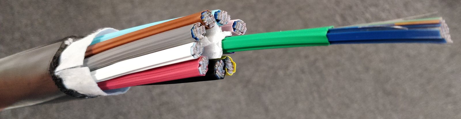 Aufgeschnittenes Glasfaserkabel mit farbigen Faserbündeln