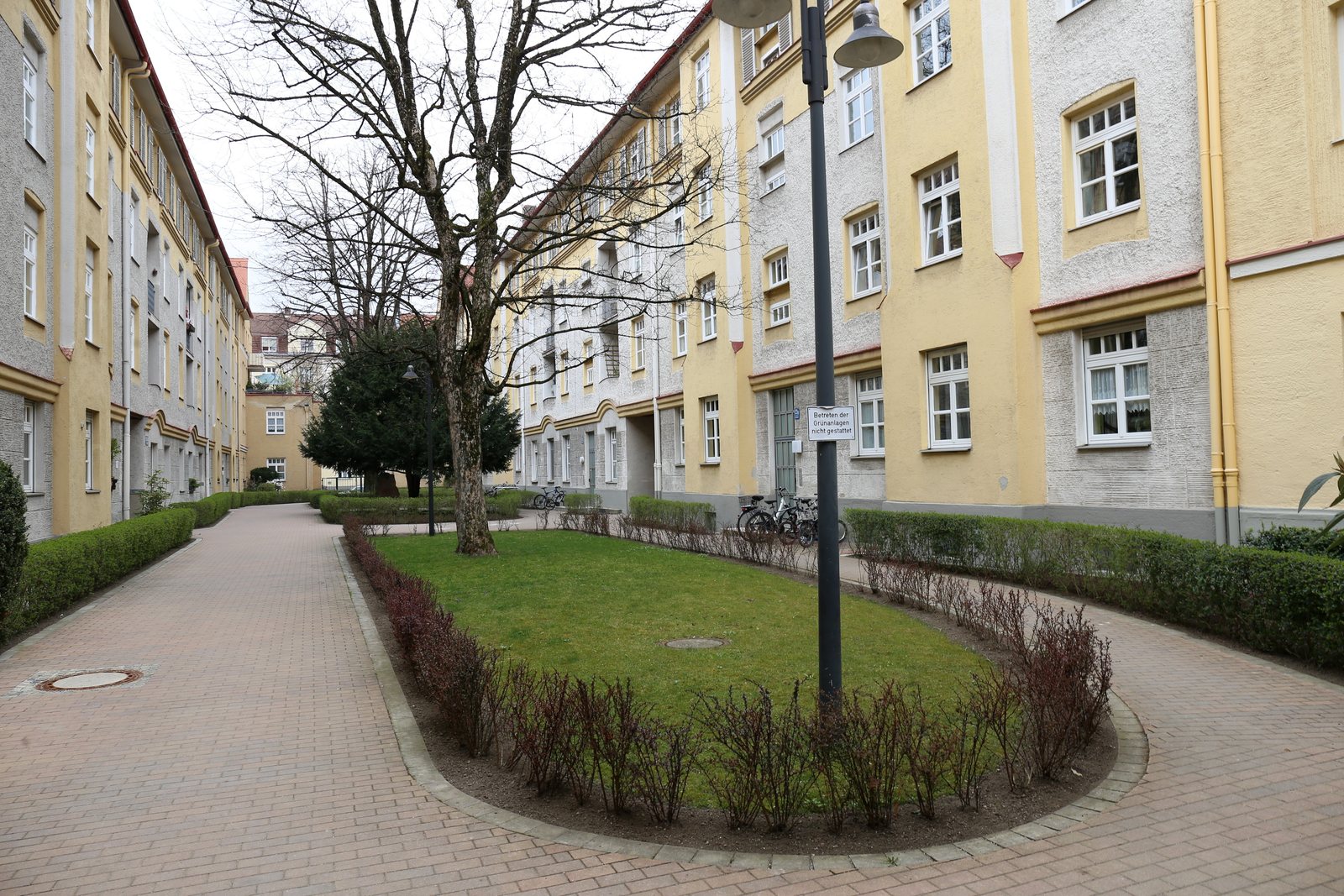 Innenhof einer Münchner Wohnanlage mit Rasen, Wegen und abgestellten Fahrrädern
