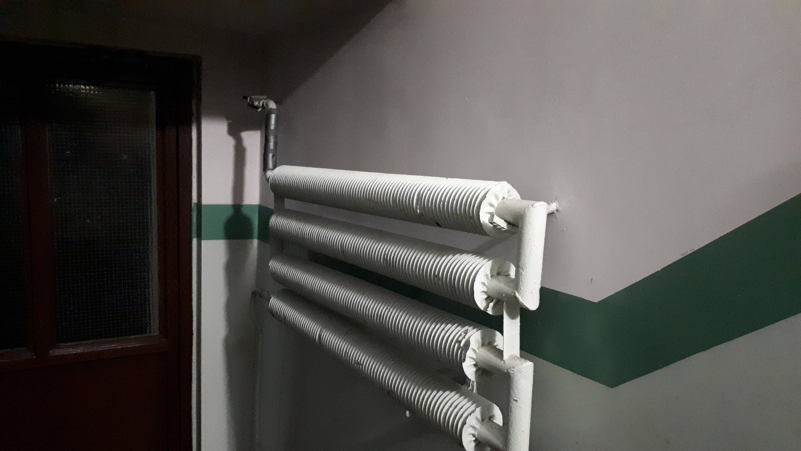 Weißer Heizkörper an der Wand eines Treppenhauses