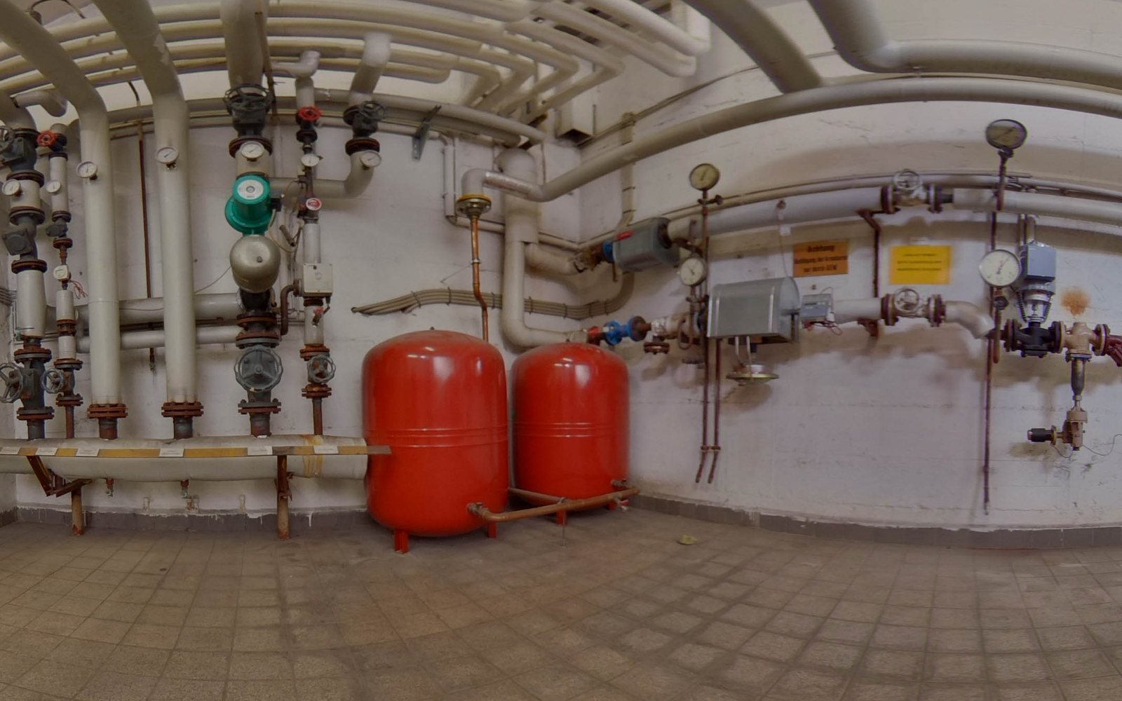 Heizungskeller mit Rohrleitungen und roten Ausdehnungsgefäßen