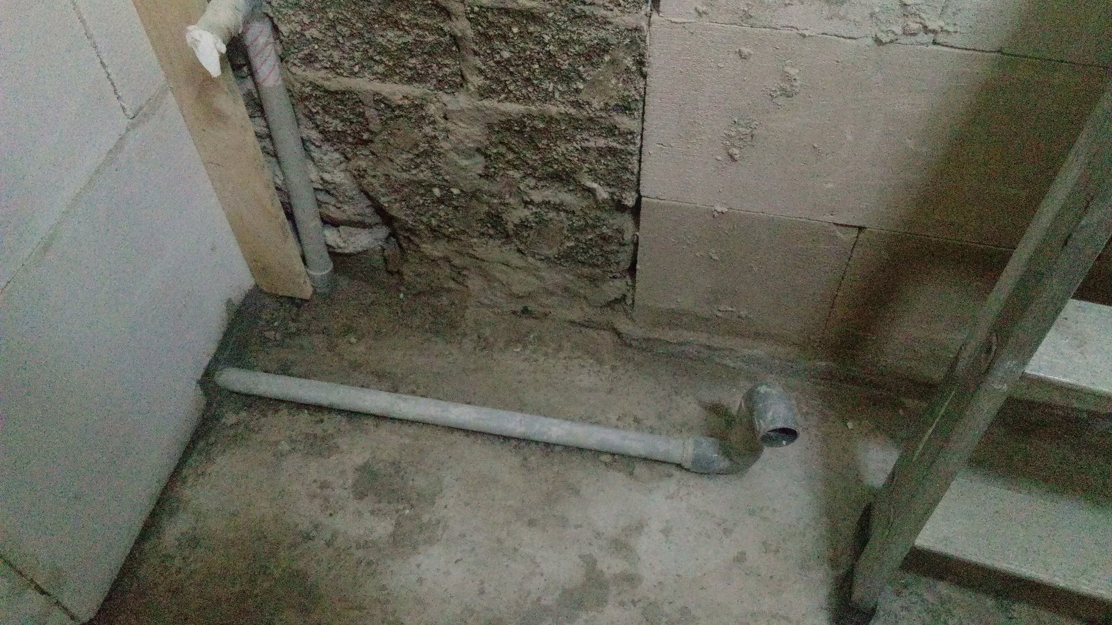 Rohbau in einer Wohnung mit freigelegter Wand und Abwasserrohr
