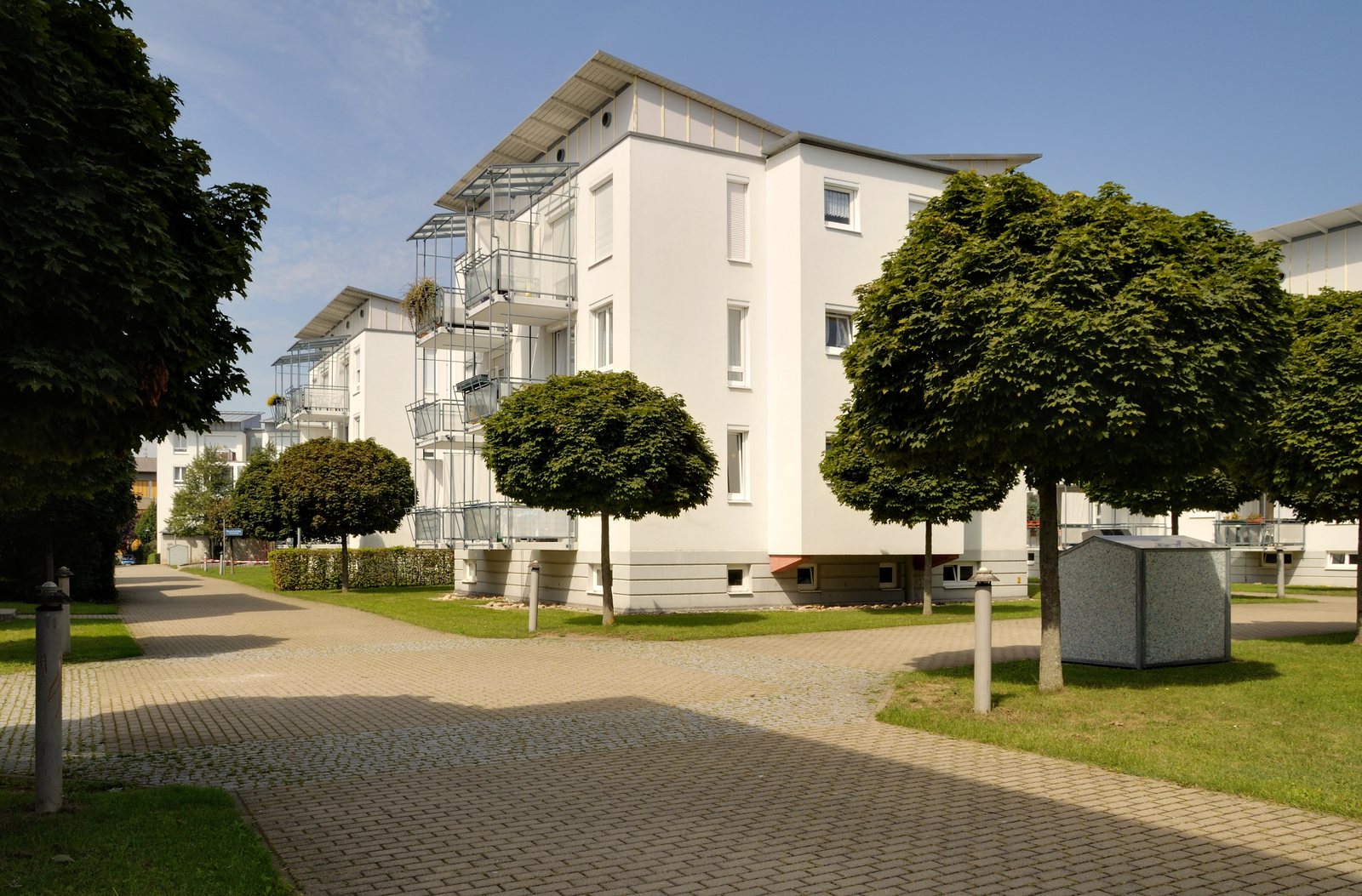 Wohnanlage mit hellen Mehrfamilienhäusern und begrüntem Innenhof