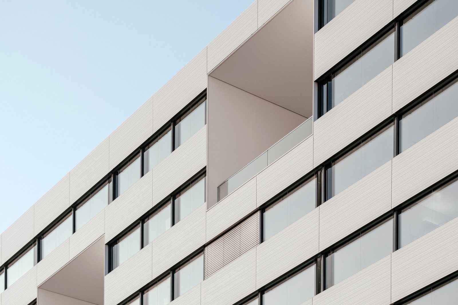 Moderne Wohnhausfassade mit Fensterbändern und Loggien