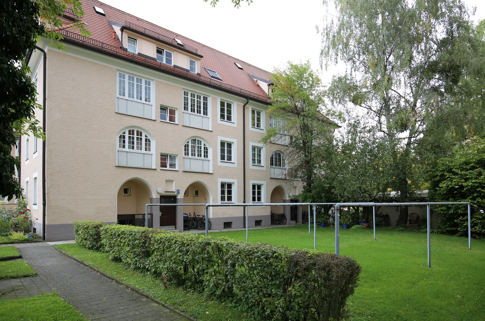 Wohnanlage mit gepflegter Rasenfläche und Hecke im Innenhof